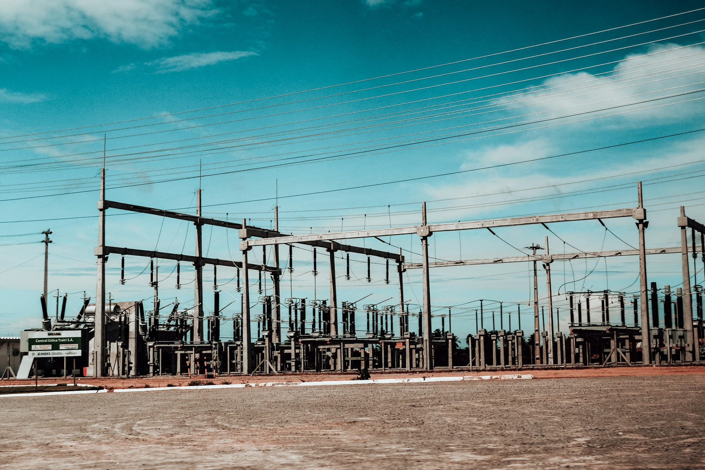 Electrical power substation with transformers and transmission lines against a blue sky